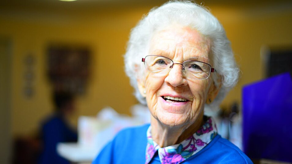 Ältere Frau lächelt in Kamera